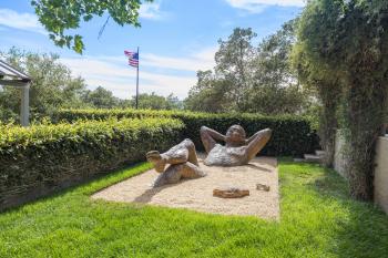 Outdoor sculpture of person reclining in sand