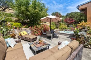 Sunny patio with sectional seating and umbrella-shaded chairs